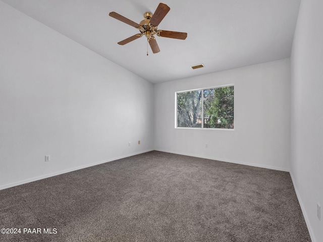 unfurnished room with ceiling fan and dark carpet