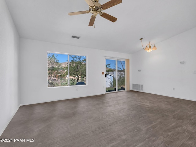 spare room featuring ceiling fan with notable chandelier and dark hardwood / wood-style floors