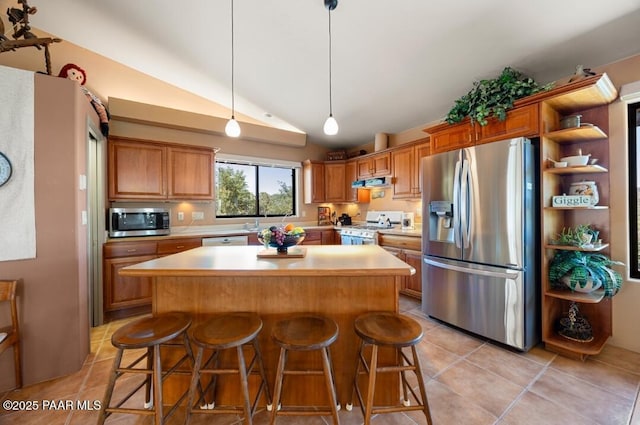 435 Fairway View Dr, Prescott, AZ 86303 - kitchen with appliances with stainless steel finishes, light countertops, lofted ceiling, a kitchen island, and light tile patterned floors