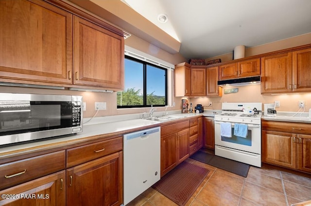 435 Fairway View Dr, Prescott, AZ 86303 - kitchen with white appliances, under cabinet range hood, brown cabinetry, light countertops, and light tile patterned floors
