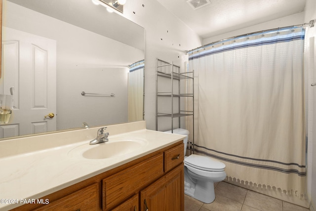 bathroom featuring tile patterned flooring, vanity, a shower with shower curtain, and toilet