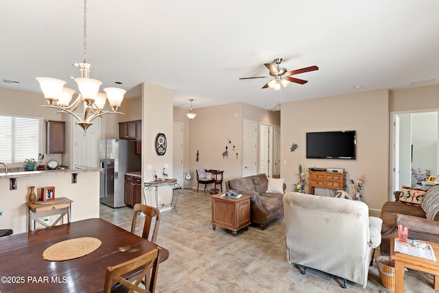 living room with visible vents and ceiling fan with notable chandelier