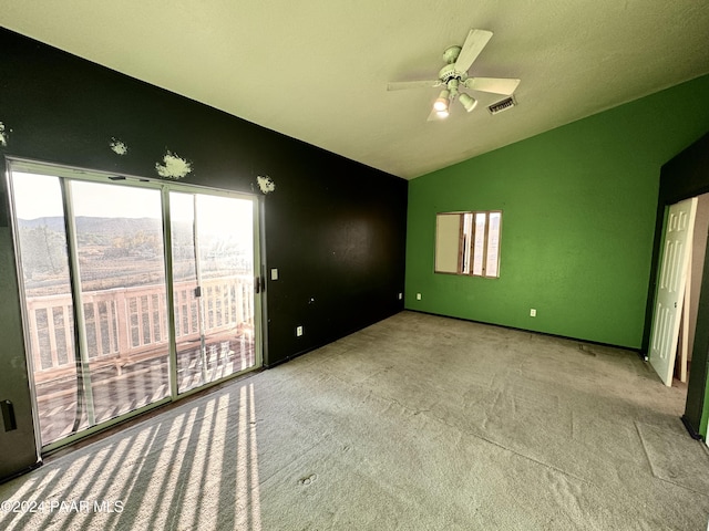 unfurnished bedroom with access to exterior, light colored carpet, vaulted ceiling, ceiling fan, and a mountain view