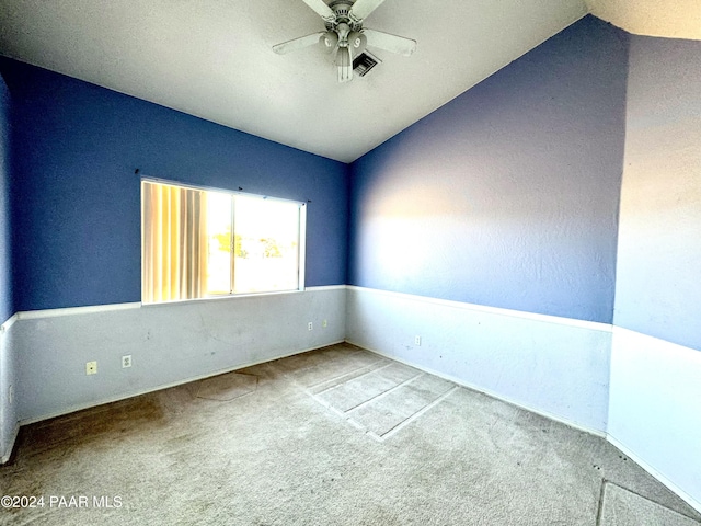 carpeted empty room with vaulted ceiling and ceiling fan