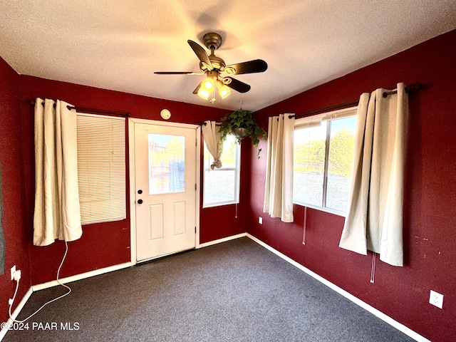 carpeted empty room with ceiling fan and a textured ceiling