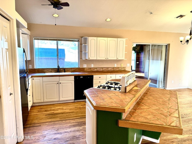 kitchen featuring black appliances, white cabinetry, sink, and tile countertops