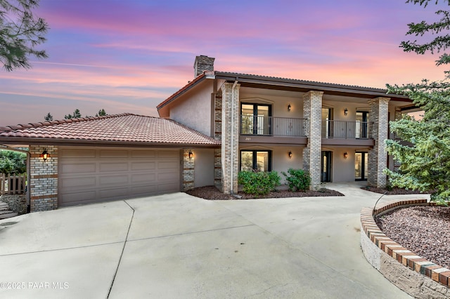 285 E Crestwood, Prescott, AZ 86303 - view of front of home featuring a tile roof, stucco siding, a balcony, driveway, and a garage