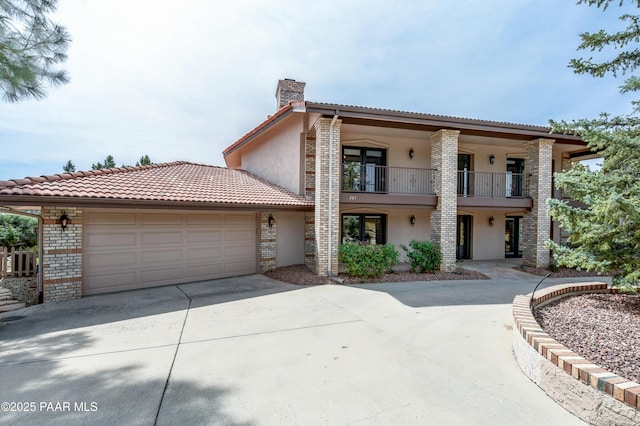 285 E Crestwood, Prescott, AZ 86303 - view of front of property with concrete driveway, a chimney, stucco siding, a balcony, and a garage