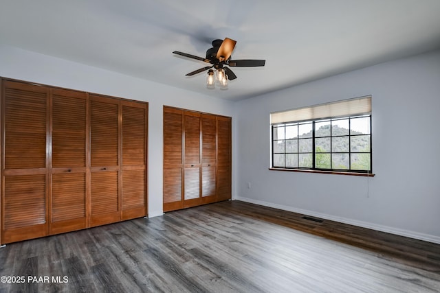 285 E Crestwood, Prescott, AZ 86303 - unfurnished bedroom with visible vents, two closets, baseboards, wood finished floors, and a ceiling fan