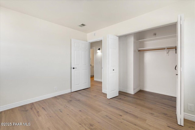 unfurnished bedroom with light wood-type flooring, visible vents, and baseboards