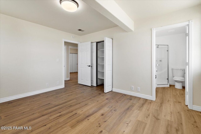 unfurnished bedroom with light wood finished floors, a closet, visible vents, and baseboards