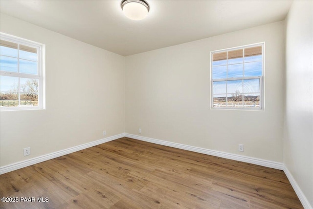 spare room with light wood finished floors and baseboards