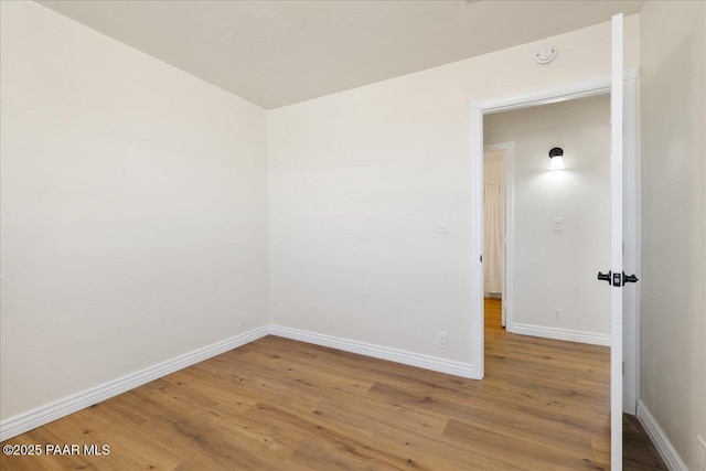 unfurnished room featuring baseboards and wood finished floors