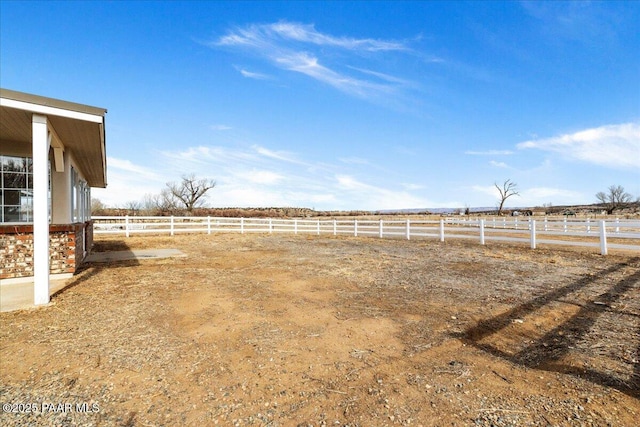 view of yard featuring a rural view and fence