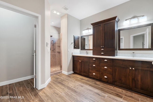 bathroom with vanity and a shower with door