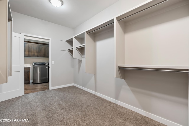 walk in closet with washer and dryer and carpet floors