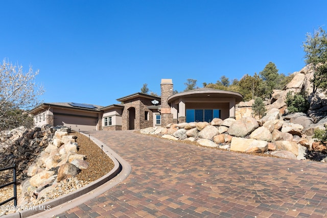 view of front of house with solar panels and a garage