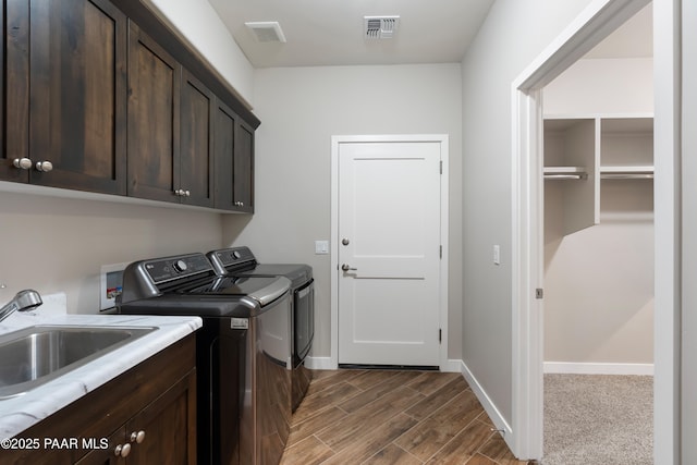 laundry area with cabinets, washing machine and dryer, and sink