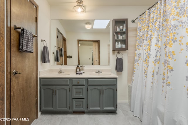 225 Sierra Rd, Sedona, AZ 86336 - full bathroom featuring a shower with shower curtain, double vanity, tile patterned flooring, and a skylight