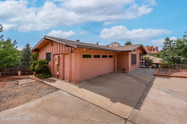 225 Sierra Rd, Sedona, AZ 86336 - view of property exterior featuring board and batten siding, concrete driveway, fence, and a garage