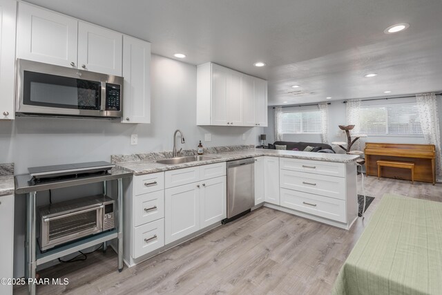 225 Sierra Rd, Sedona, AZ 86336 - kitchen featuring appliances with stainless steel finishes, a sink, white cabinets, a peninsula, and light wood finished floors