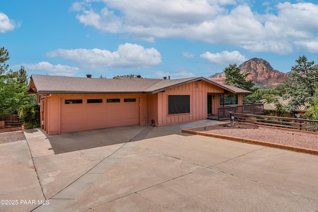 225 Sierra Rd, Sedona, AZ 86336 - view of front of property with board and batten siding, an attached garage, a mountain view, fence, and driveway