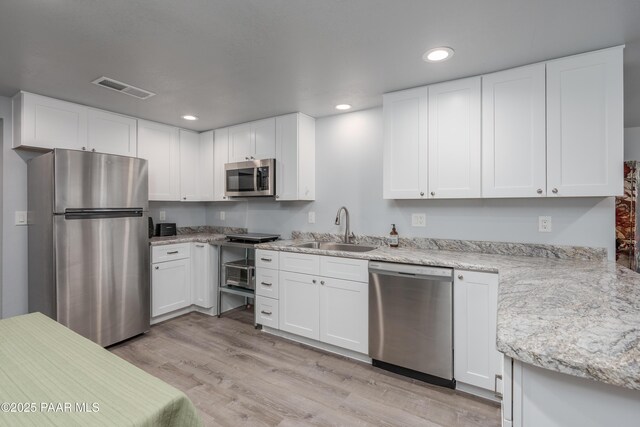 225 Sierra Rd, Sedona, AZ 86336 - kitchen featuring stainless steel appliances, a sink, light wood-style flooring, white cabinetry, and recessed lighting