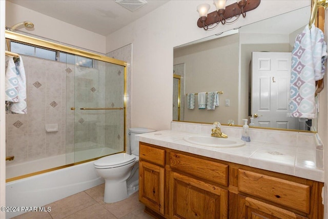 full bathroom with shower / bath combination with glass door, tile patterned floors, vanity, and toilet