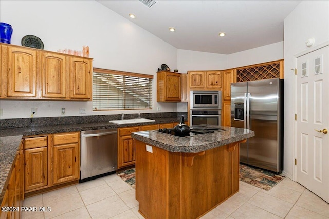 kitchen featuring sink, high vaulted ceiling, light tile patterned flooring, a kitchen island, and appliances with stainless steel finishes