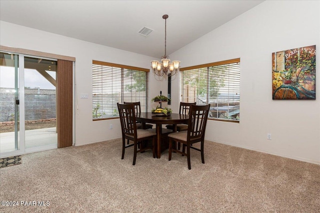 dining area featuring a chandelier, light colored carpet, and vaulted ceiling