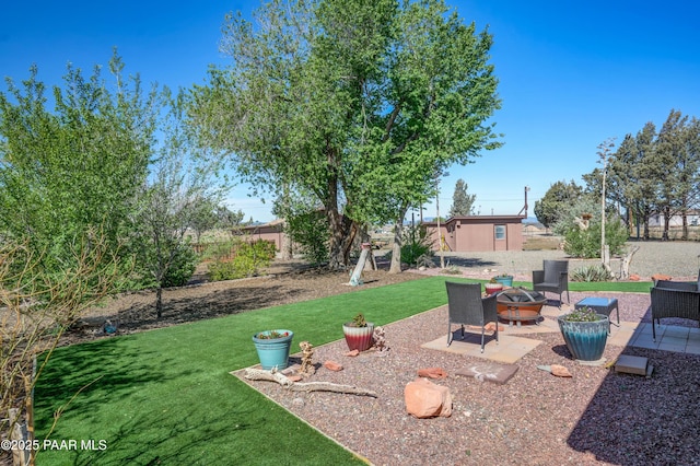 24585 N Catalina St, Paulden, AZ 86334 - view of green lawn featuring a fire pit, a patio, and an outdoor structure