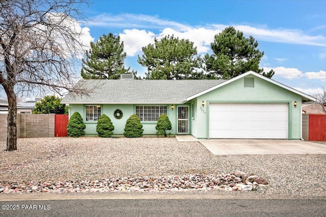 ranch-style house featuring concrete driveway, an attached garage, fence, and stucco siding