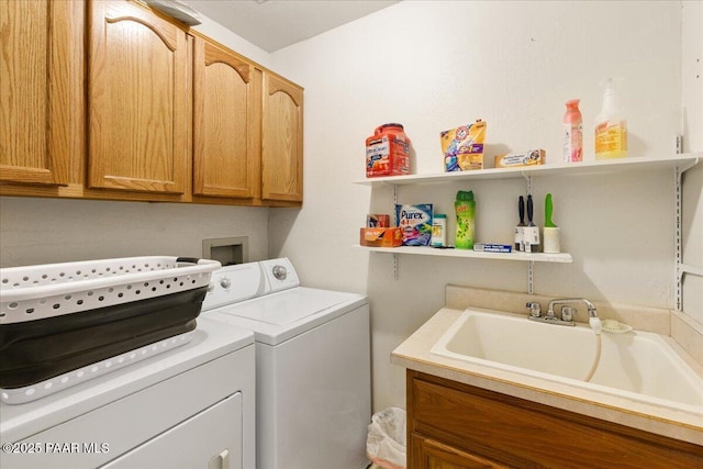 clothes washing area featuring independent washer and dryer, a sink, and cabinet space