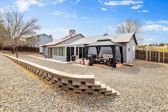 rear view of property featuring an outdoor hangout area, a patio, a gazebo, and a fenced backyard