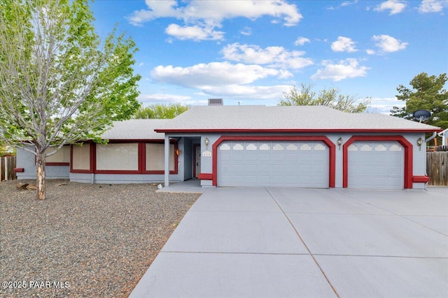 view of front of house featuring concrete driveway, a shingled roof, and a garage