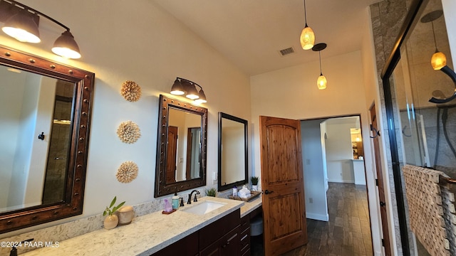 bathroom featuring hardwood / wood-style floors, vanity, lofted ceiling, and walk in shower