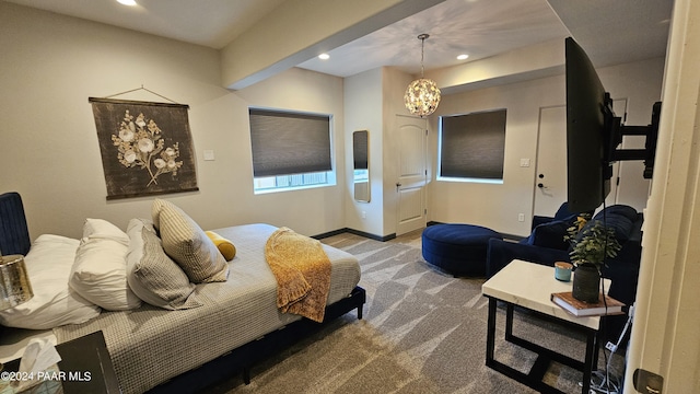 carpeted bedroom with a notable chandelier