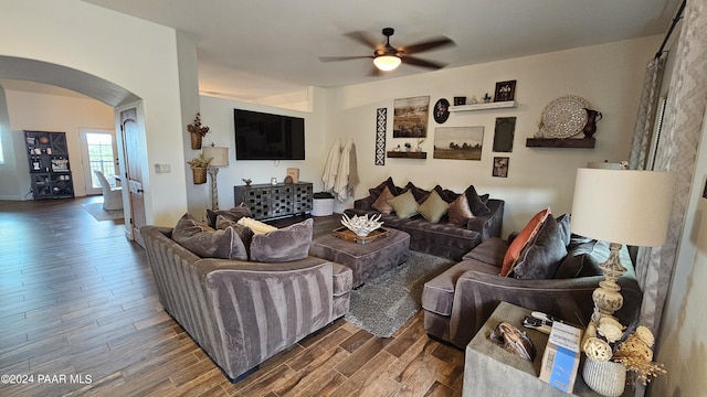 living room with ceiling fan and dark wood-type flooring