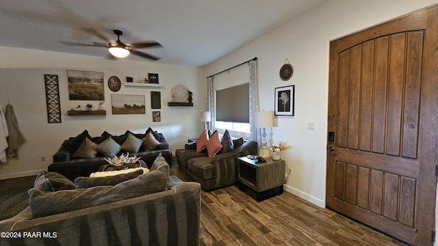 living room with ceiling fan and dark wood-type flooring