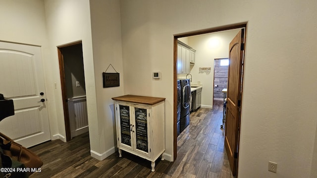 corridor with dark hardwood / wood-style flooring and independent washer and dryer