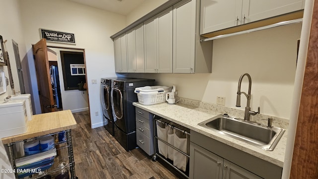 kitchen with dark hardwood / wood-style flooring, sink, gray cabinets, and washing machine and clothes dryer