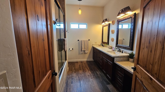 bathroom with hardwood / wood-style floors, plenty of natural light, an enclosed shower, and vanity