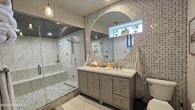 bathroom featuring vanity, a shower with shower door, tile walls, and toilet