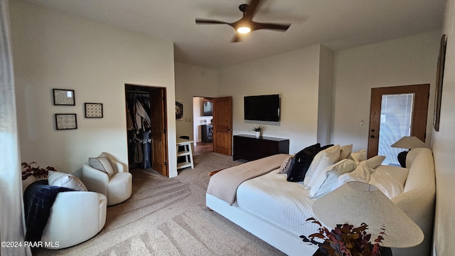 carpeted bedroom with a walk in closet, ceiling fan, and a closet