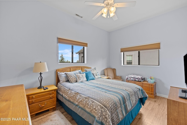 bedroom featuring ceiling fan, wood finished floors, visible vents, and baseboards