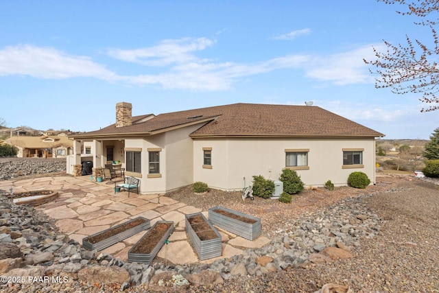 back of house featuring a patio area, stucco siding, and a chimney