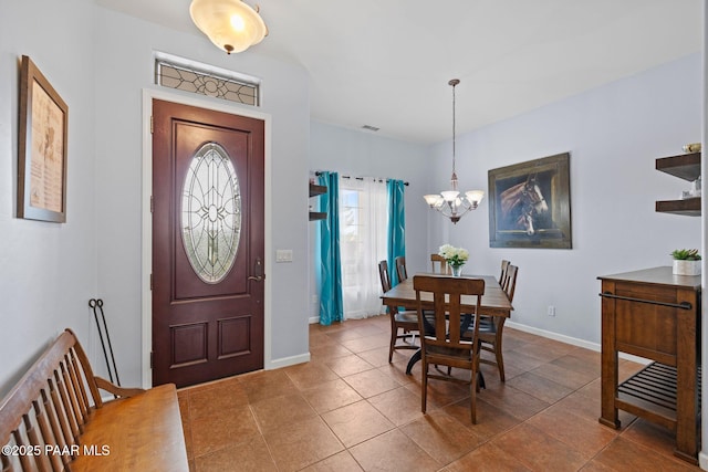 entrance foyer featuring tile patterned flooring, an inviting chandelier, visible vents, and baseboards