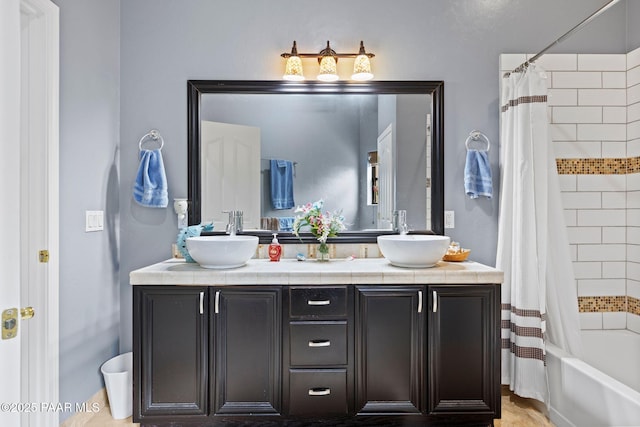 full bath featuring double vanity, shower / bath combo with shower curtain, and a sink