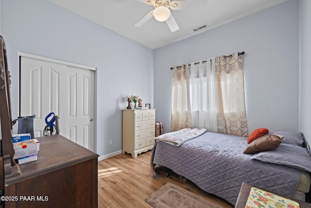 bedroom with visible vents, baseboards, ceiling fan, light wood-style flooring, and a closet