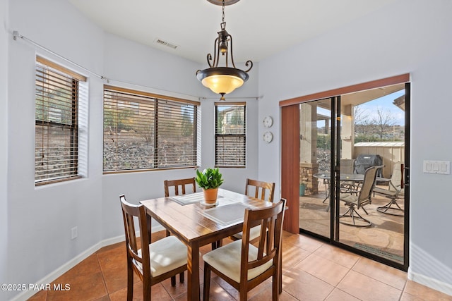 dining area with light tile patterned flooring, visible vents, and baseboards